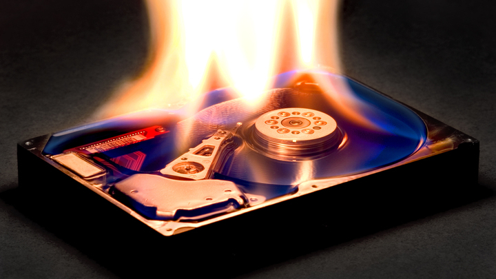 A hard drive on fire, symbolizing the catastrophic data loss caused by Google's Antigravity AI