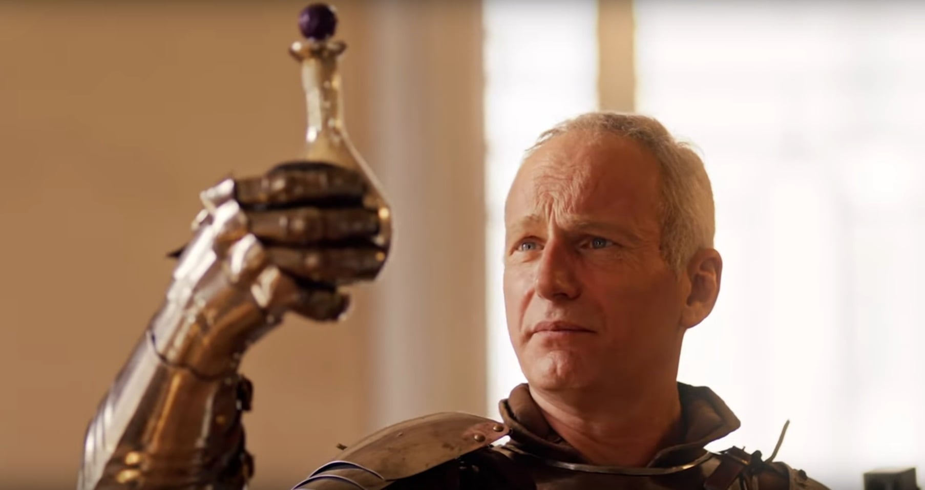 A man holds up a vial of strange liquid