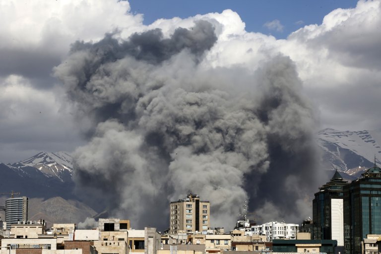Dark smoke rising over city buildings after a strike