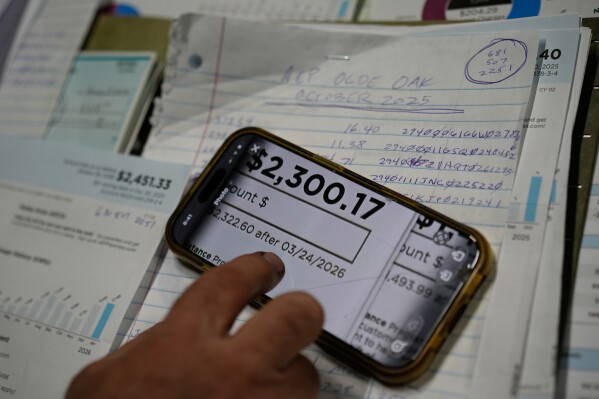 Eric Pinson, manager and resident of the Lock 24 RV Park and Campground, one of two such locations he manages in the area, looks over the business' electric bills, at his home at the campground in Racine, Ohio, March 13, 2026. (AP Photo/Carolyn Kaster, File)