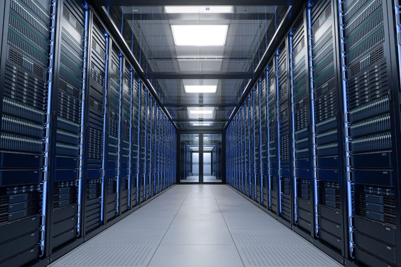 The inside of a data center showcasing rows of server racks and cooling systems.